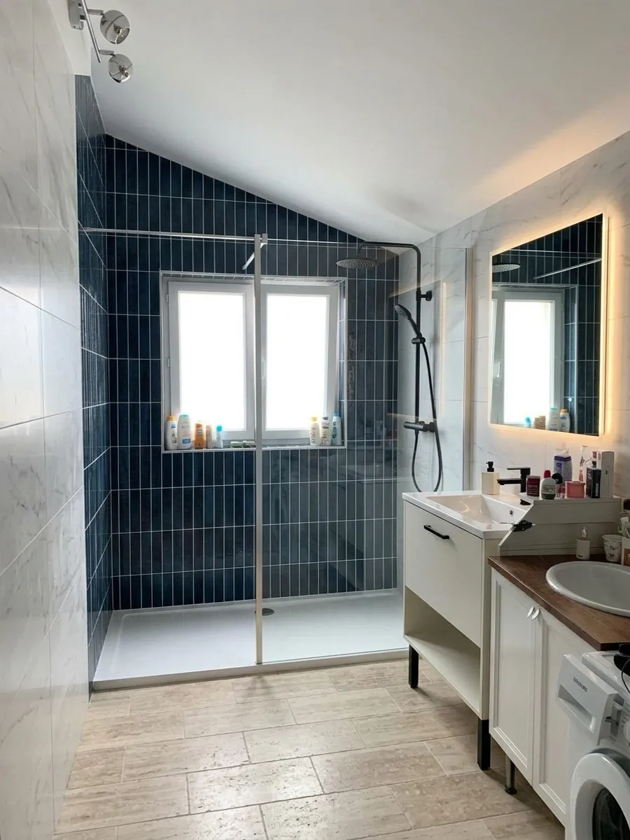 La même salle de bain après rénovation avec les panneaux Carrelo Bleu foncé 30 × 7 et Marbre blanc